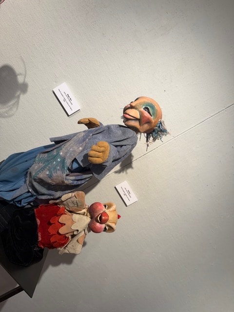 Wall-mounted puppet figures on display — State of the Art: Connecticut Puppetry Exhibit
